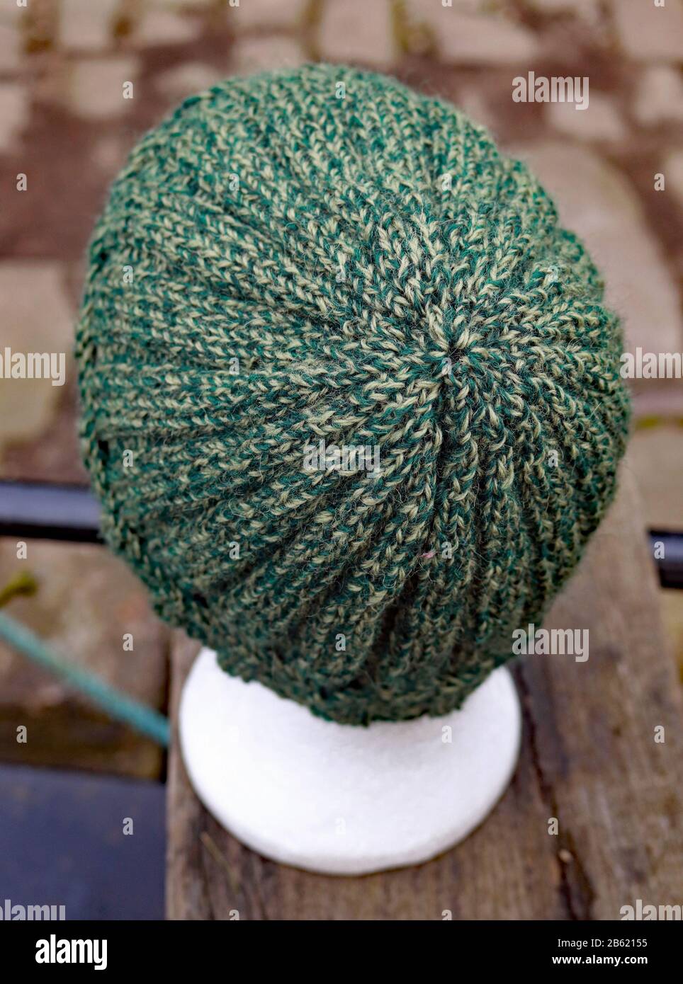 A ribbed textured adults hat hand knitted from pure British wool in tweedy shades of green. Stock Photo