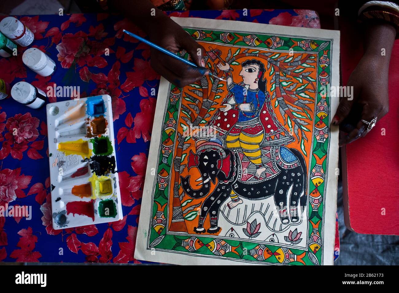Young woman taking drawing lessons in a drawing school ( India). She is learning the Madhubani style of painting. Stock Photo