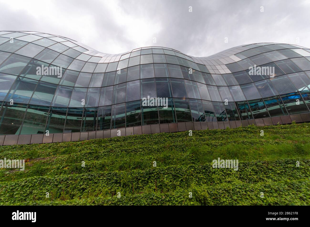 Gateshead, England, UK - May 26, 2011: Grey skies are reflected in the modernist glass Sage Gateshead building. Stock Photo