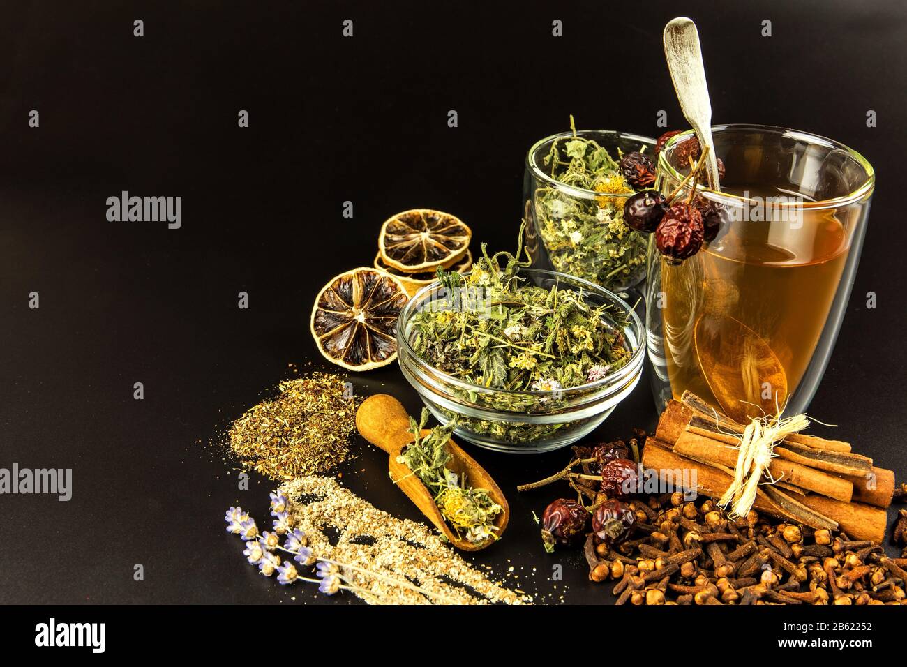 https://c8.alamy.com/comp/2B62252/cup-of-herbal-tea-various-herbal-tea-ingredients-in-glass-jars-over-black-background-traditional-medicine-against-flu-and-cold-2B62252.jpg