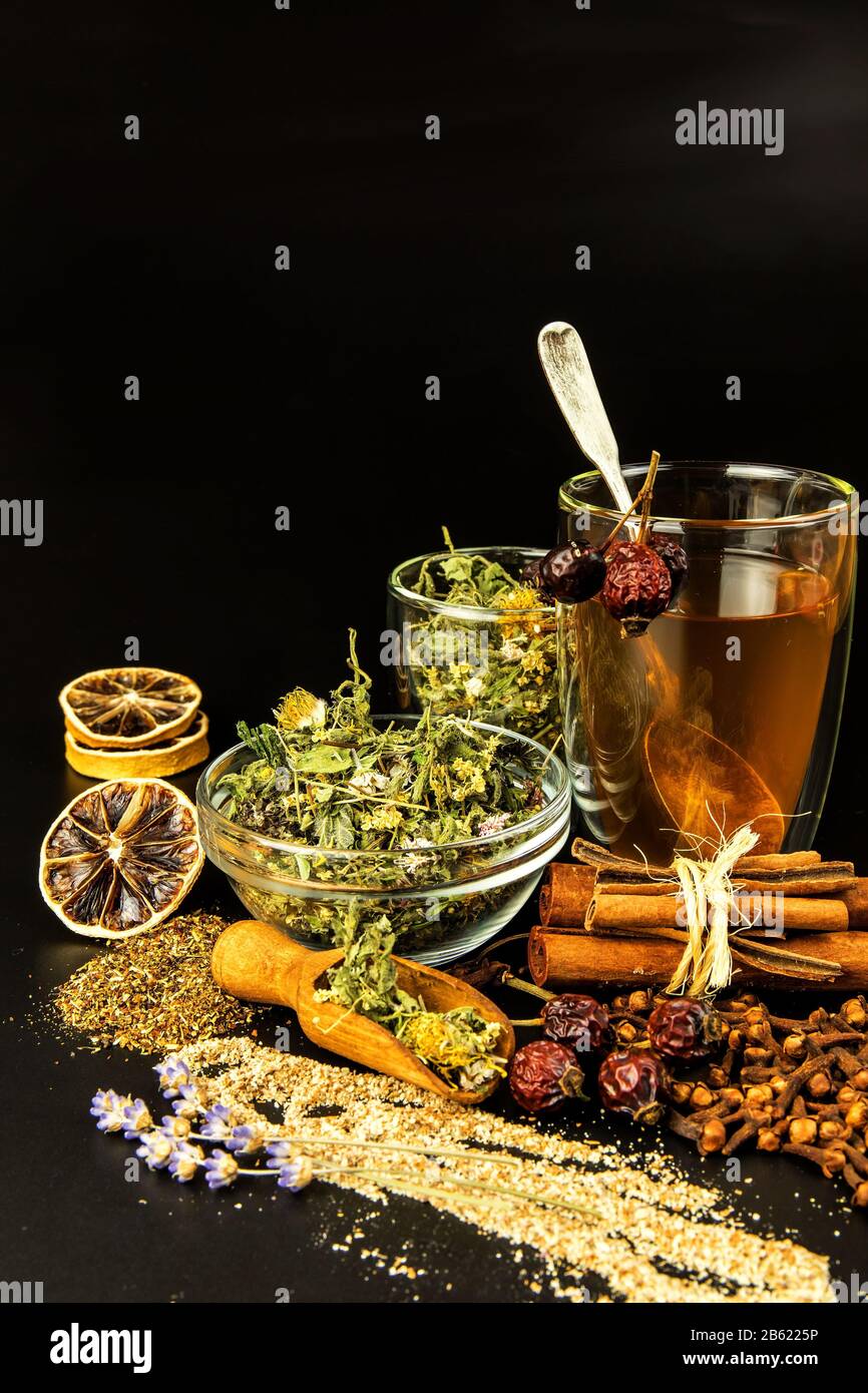 https://c8.alamy.com/comp/2B6225P/cup-of-herbal-tea-various-herbal-tea-ingredients-in-glass-jars-over-black-background-traditional-medicine-against-flu-and-cold-2B6225P.jpg