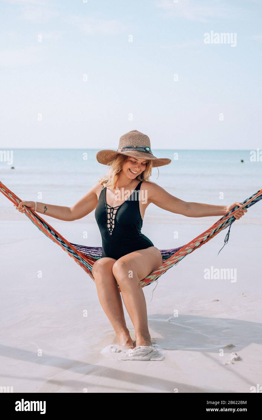 A woman sits in a hammock at the beach in Holbox, Mexico Stock Photo