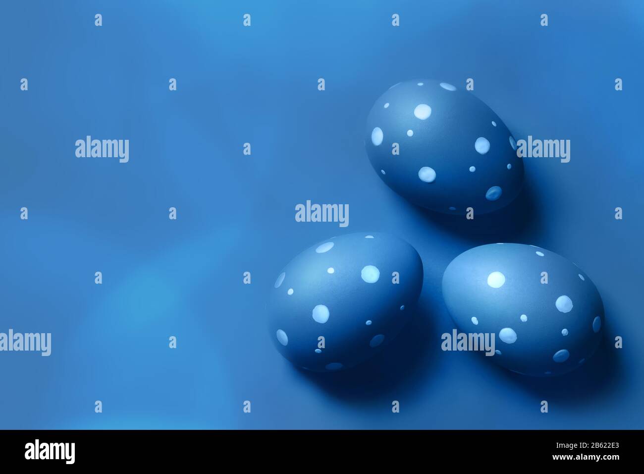 Colored decorated eggs on blue background. Easter concept, card with free copy space. Stock Photo