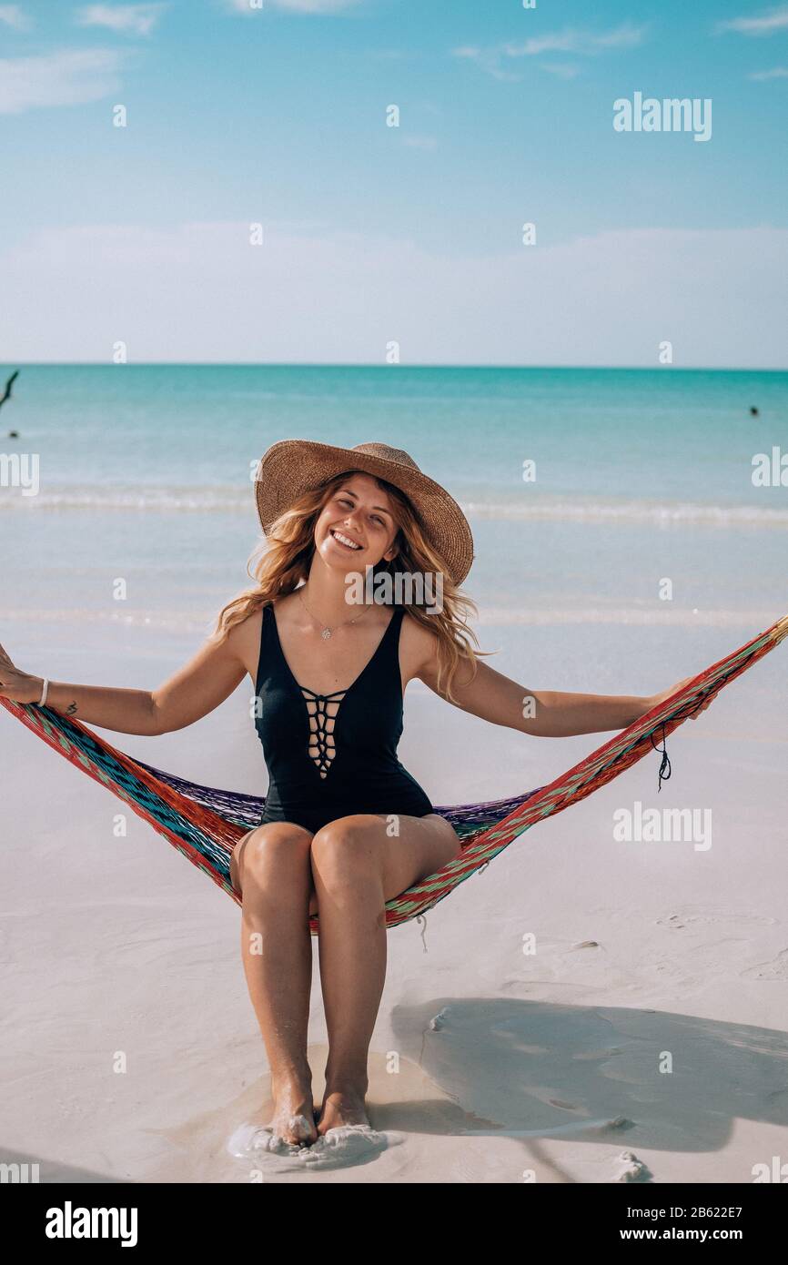 A woman sits in a hammock at the beach in Holbox, Mexico Stock Photo