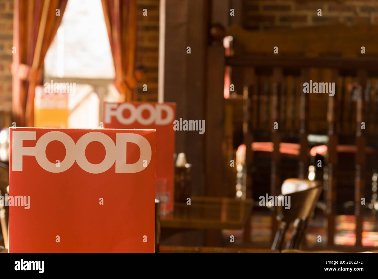 Menus with the word Food printed on them in an empty pub style restaurant in the UK Stock Photo