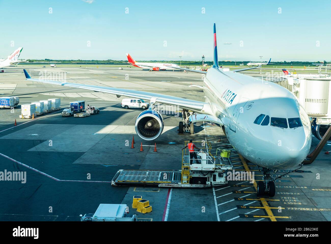 New York City, USA - August 4, 2018: Worker loading and unloading goods in Delta Air Lines airplane parked at John F. Kennedy International Airport (J Stock Photo