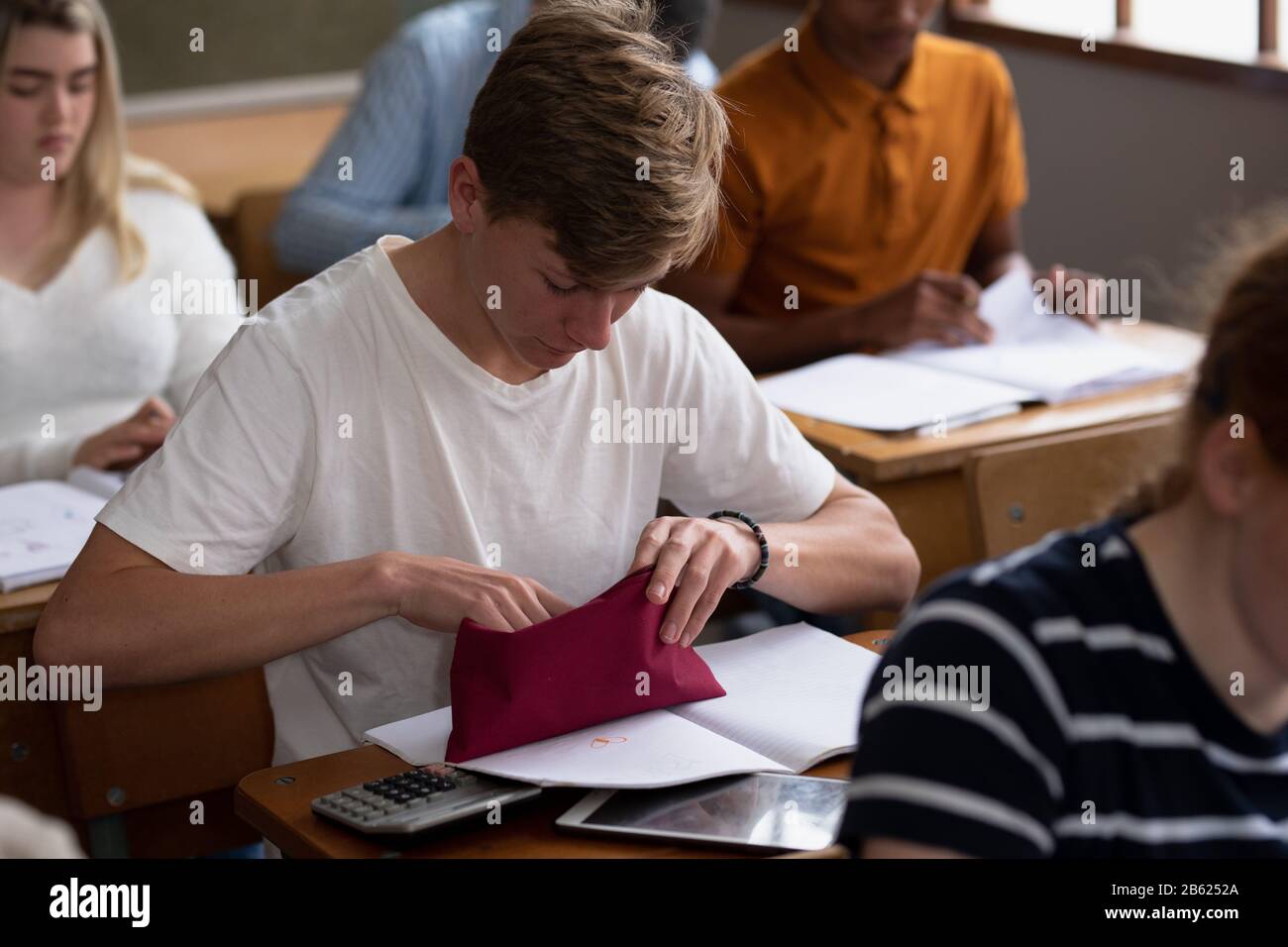 Side view of student choosing a pen to write Stock Photo