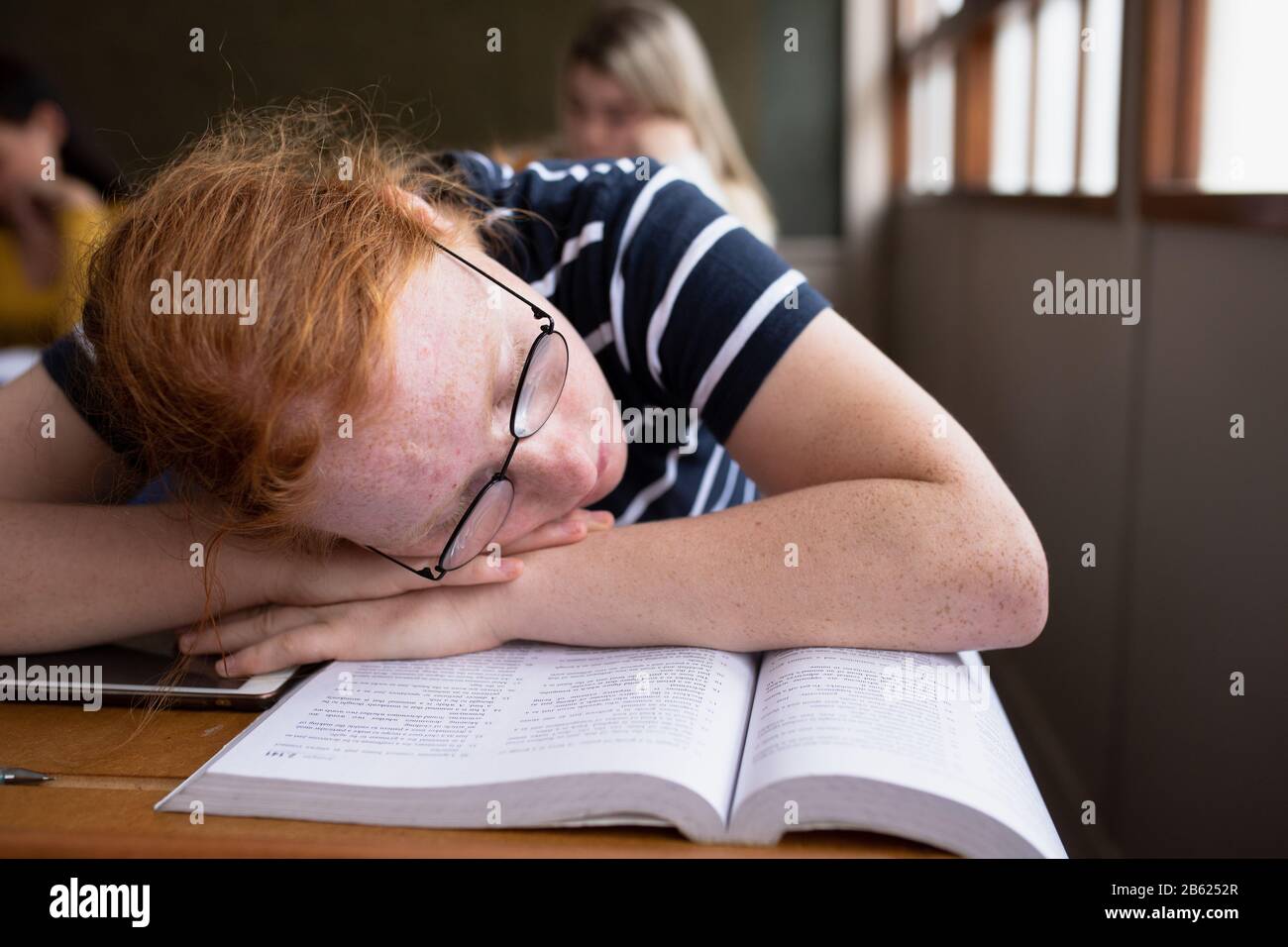 Front view of student sleeping in class Stock Photo
