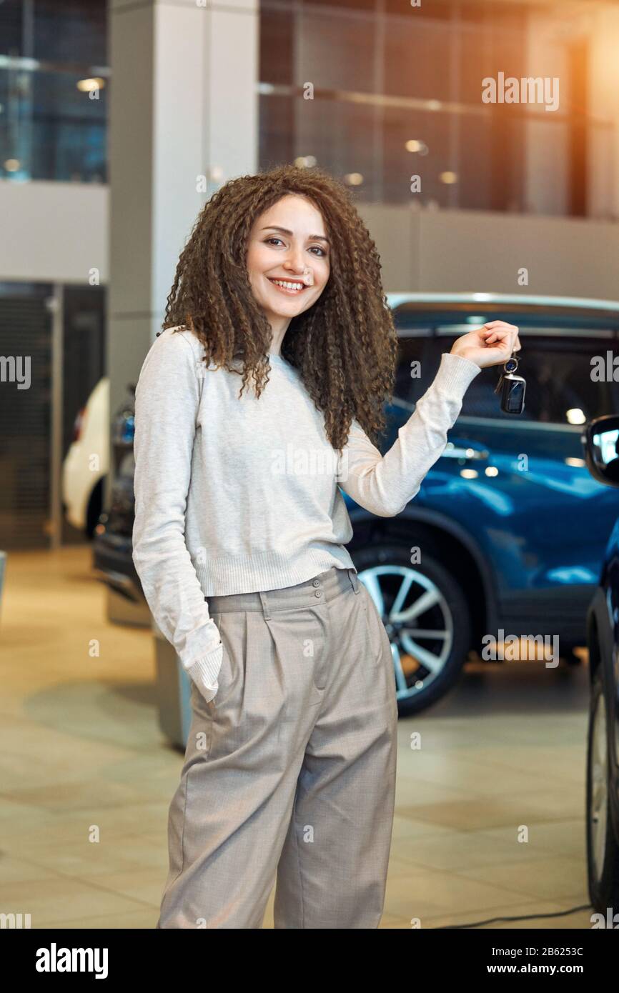attractive positive girl is happy as she has won the car, close up photo. girl has got a car on her birthday, unforgettable present, successful shoppi Stock Photo