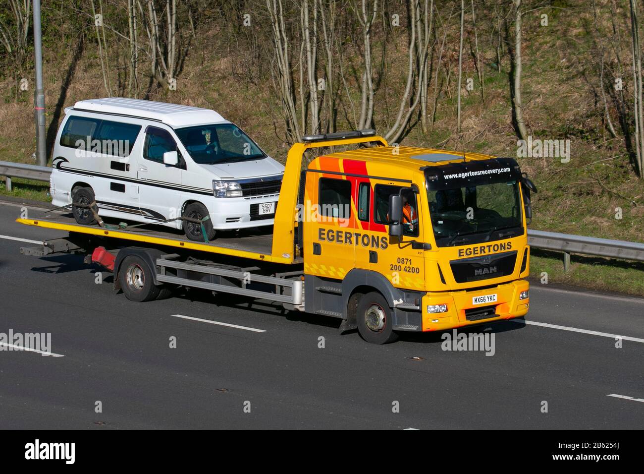 Egertons Breakdon Recovery;  Haulage delivery trucks, lorry, transportation, truck, cargo, MAN vehicle, delivery, commercial transport, industry, supply chain freight, on the M6 at Lancaster, UK Stock Photo