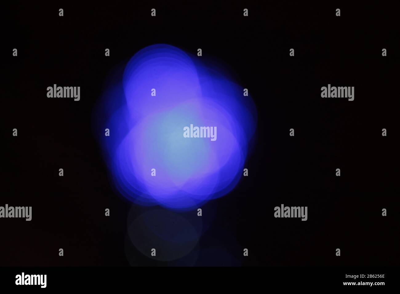 Colored blurry spots of blue, violet, lilac and purple on a black background. Element for design, place for text. Stock Photo