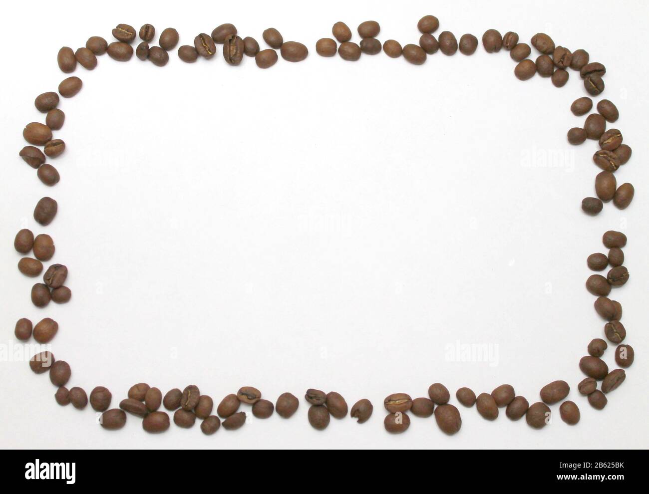 Brown coffee beans lie on a white background in the form of a rectangular frame. Isolated for text and design. Stock Photo