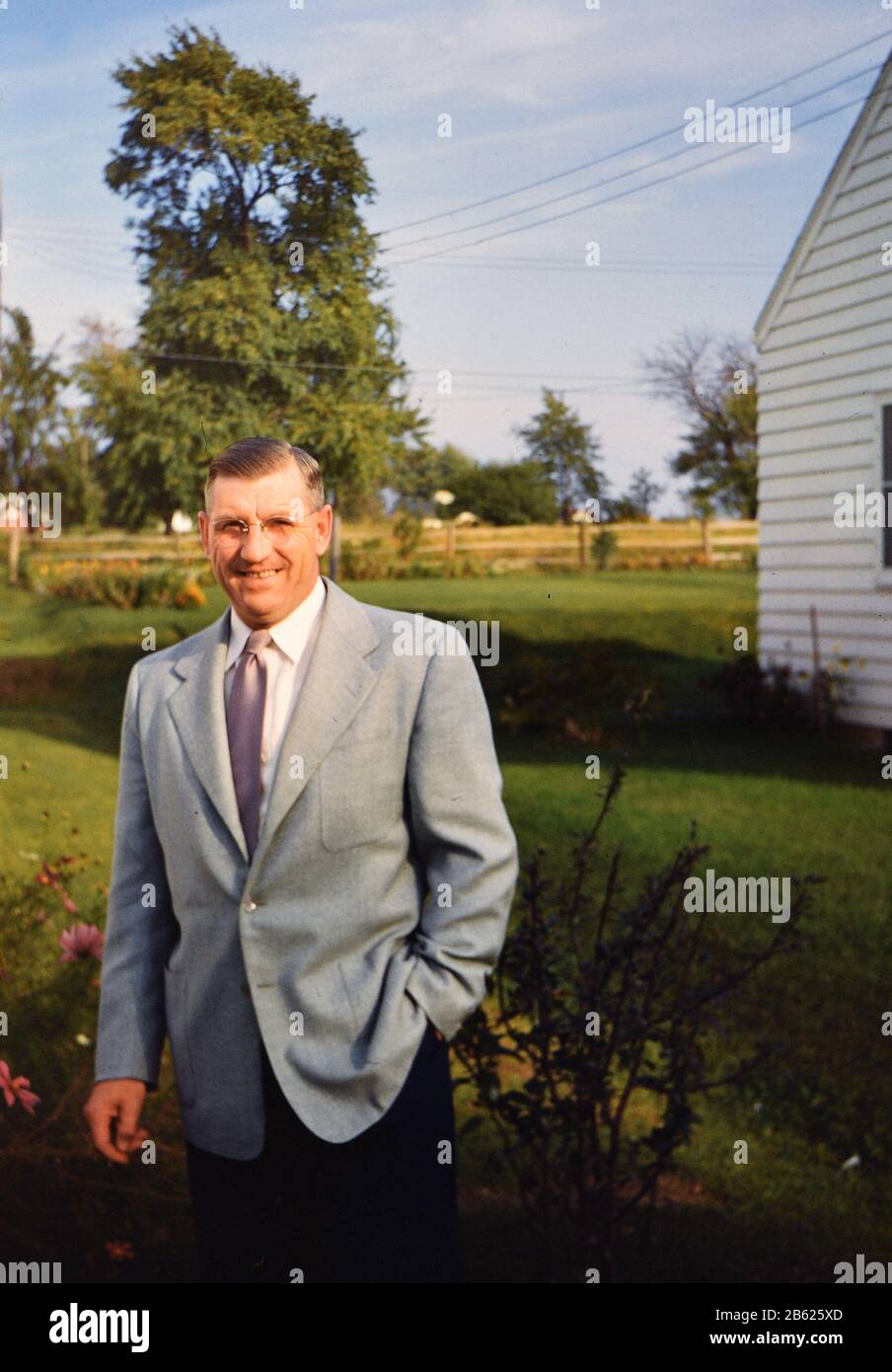 Sharp dressed man wearing a suit posing for a photo outside his home in ...
