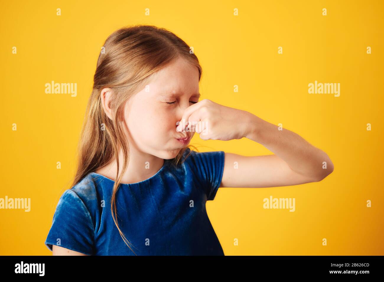 Little Redhead Girl Covering Nose For Bad Smell Stock Photo
