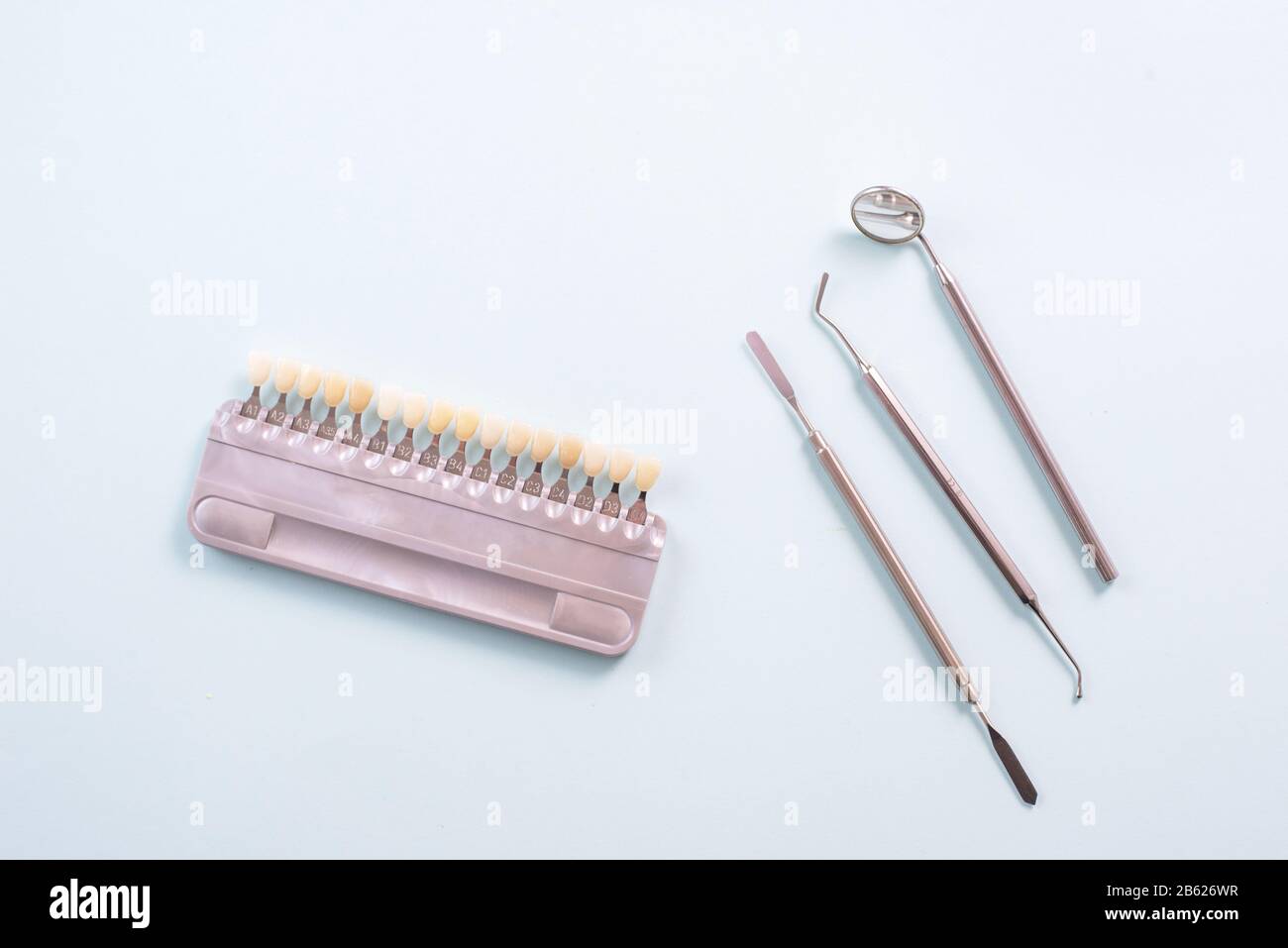 Color palette of different shades of teeth and dental tools on a blue