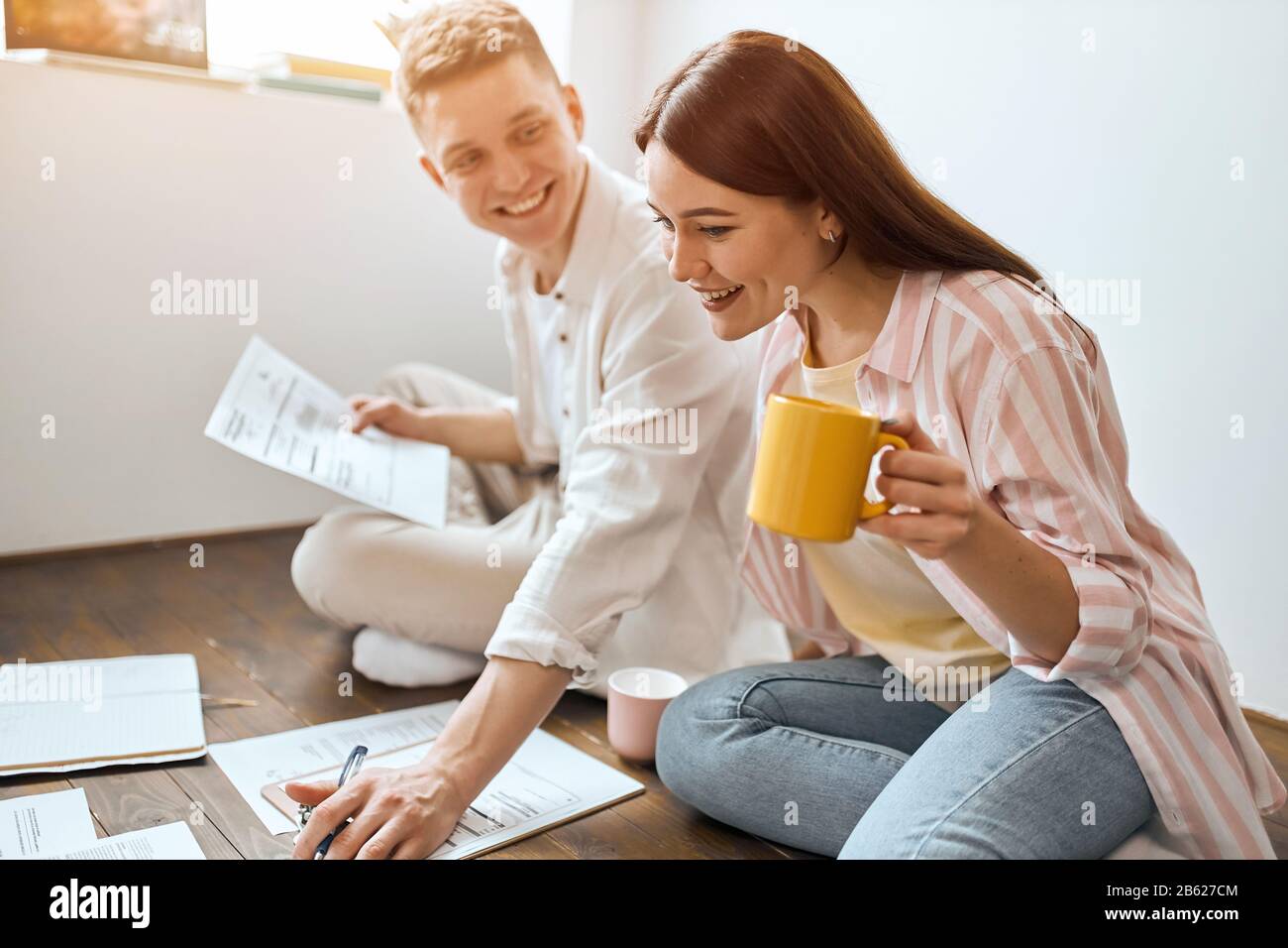 young cheerful happy family havinf fun in the living room, spare time, lifestyle, young man and woman earning much money, close up side view photo Stock Photo