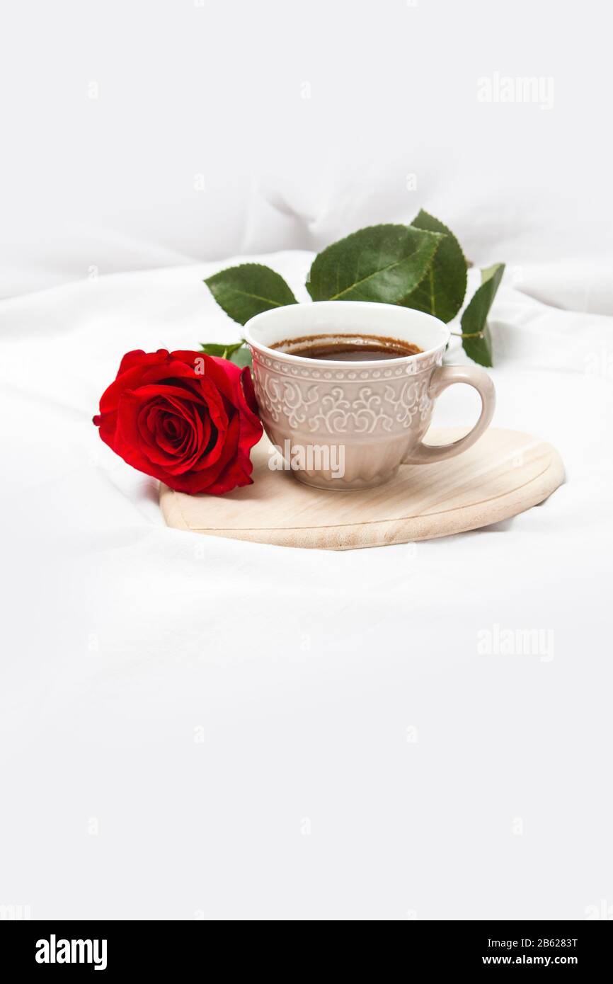 Black coffee with red rose on a white sheet Stock Photo
