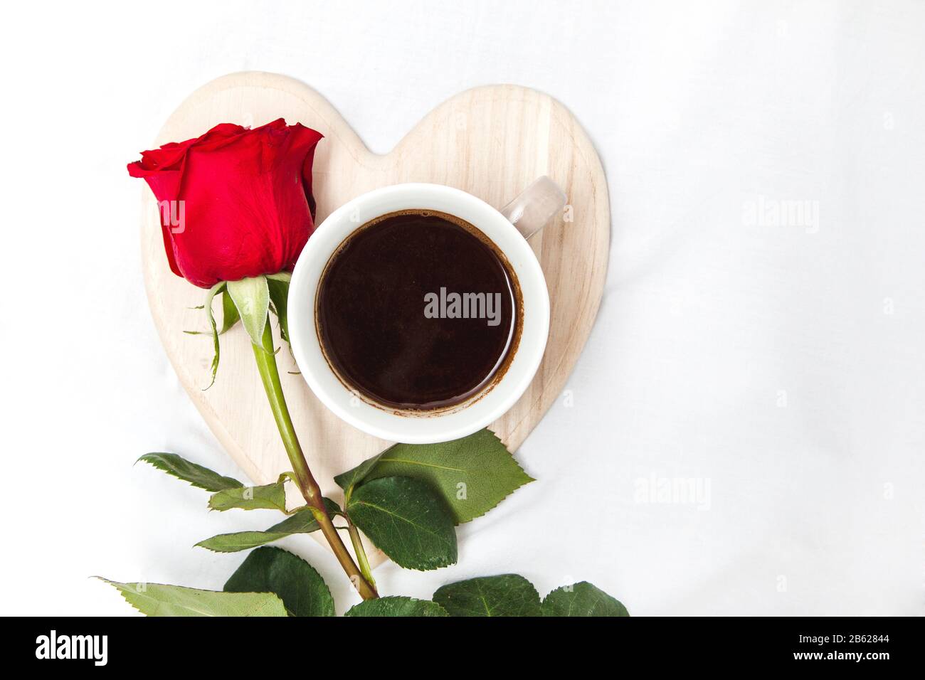 Black coffee with red rose on a white sheet Stock Photo