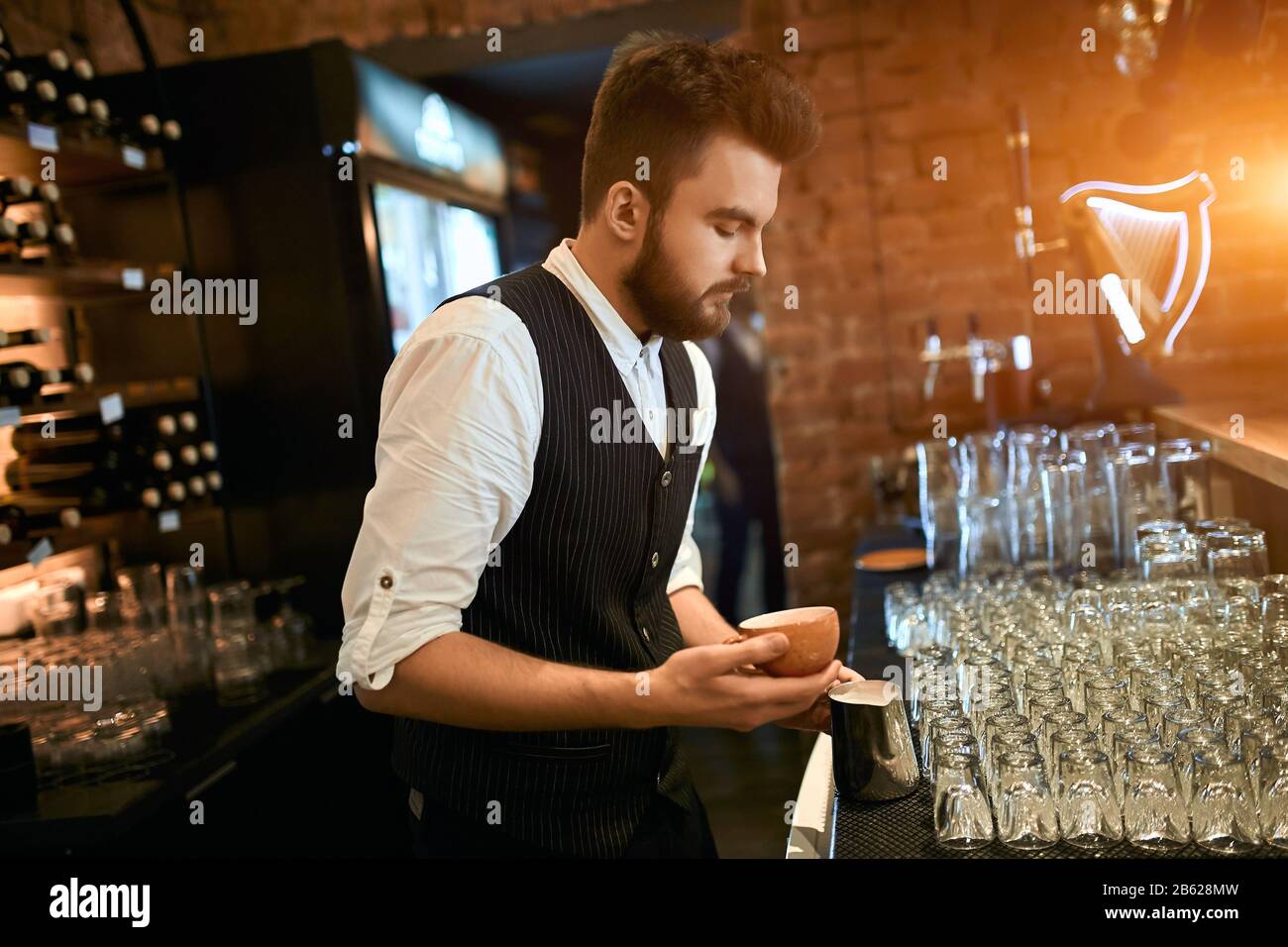 young man creating pleasant taste of coffee, art , creativity concept , duty , close up side view photo, small business Stock Photo