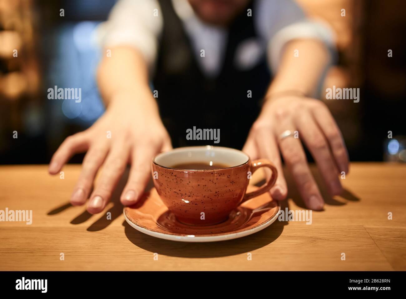 black coffee in orange cup on brown wooden table blurred background.sale discount . close up cropped photo Stock Photo
