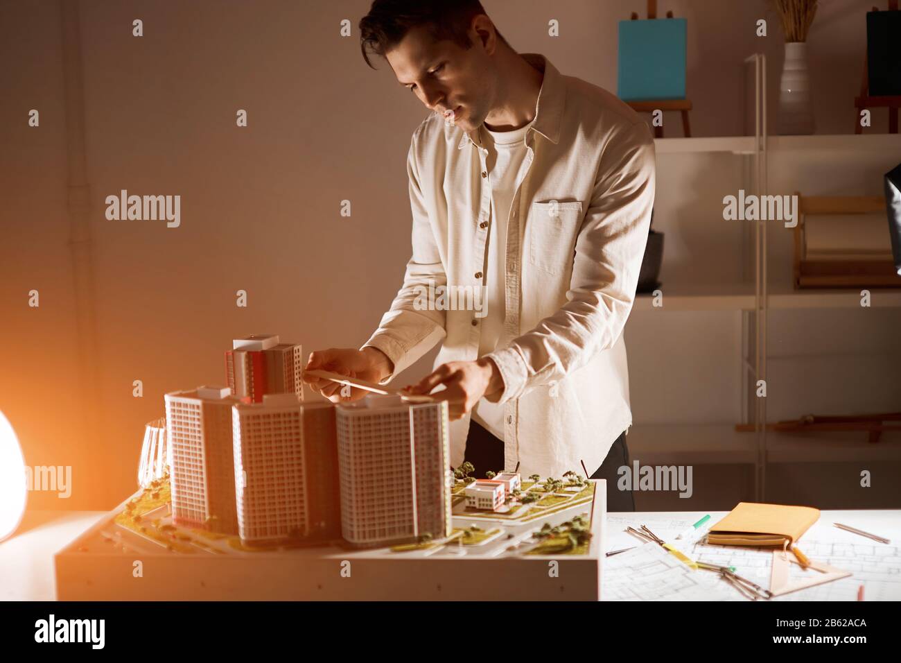 young blonde guy using engineering tools while working in a model office, close up side view pho Stock Photo