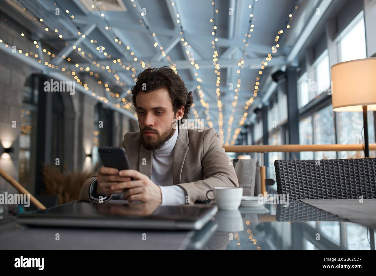 serious guy having a rest at the cafe, watching video, movie, film, close up photo. student reading e-book in the cafe Stock Photo