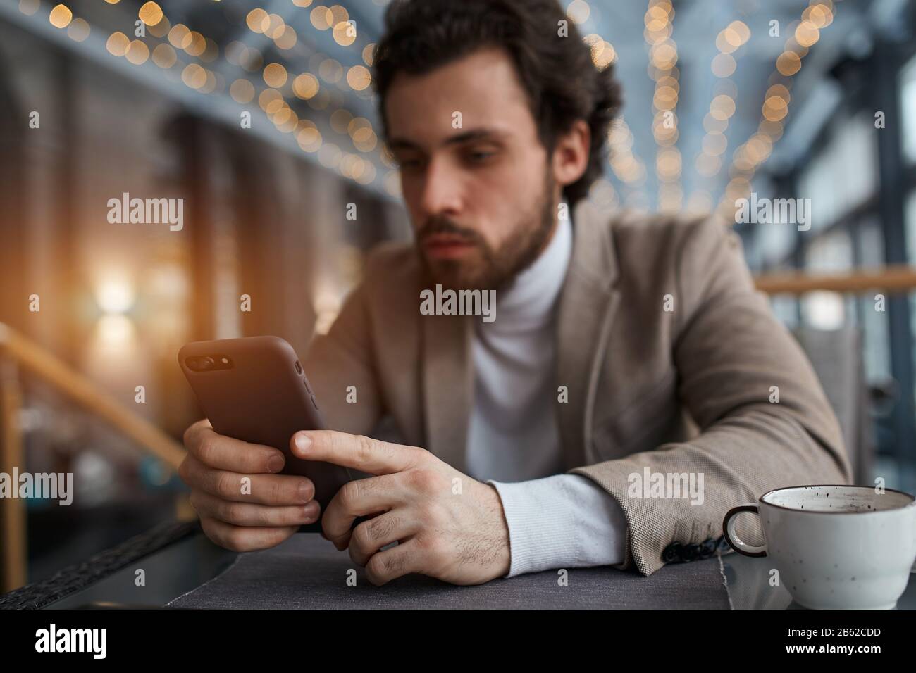 focus on the smart phone blurred image, guy doing shopping online, close up photo. man concentrated on working with gadget Stock Photo