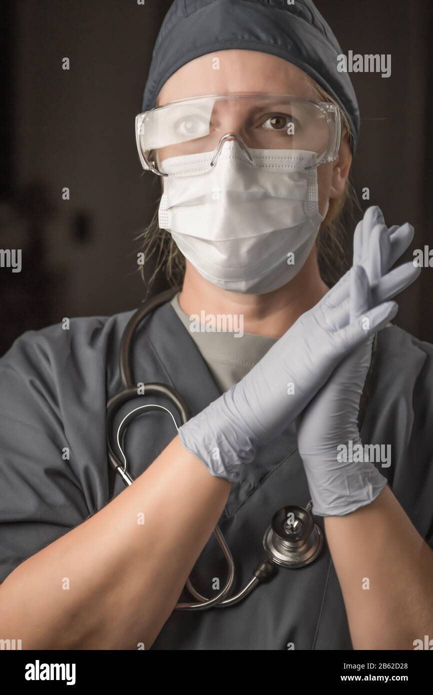 Female Doctor or Nurse Wearing Scrubs, Protective Face Mask and Goggles
