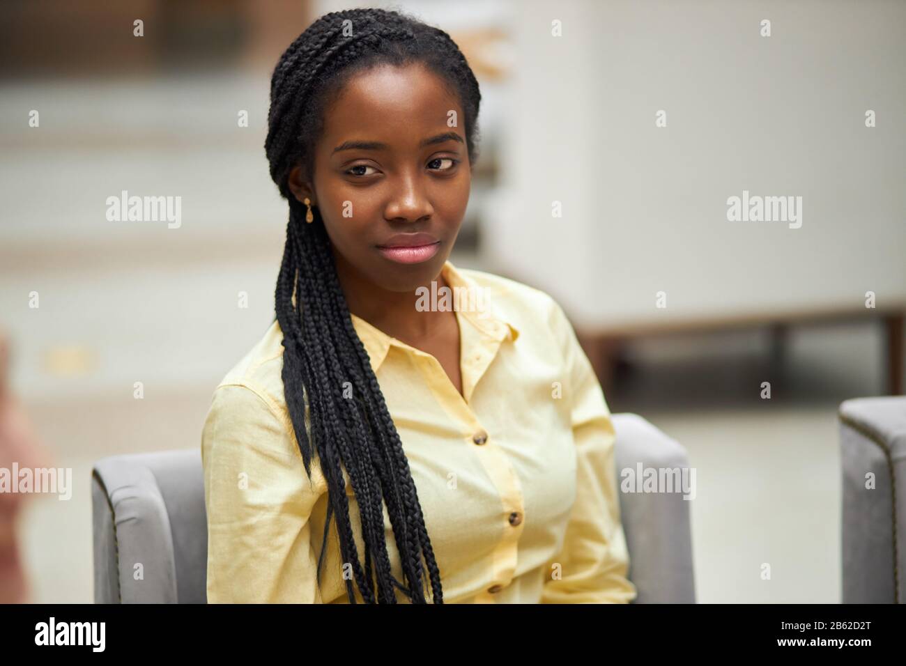 young attractive serious pensive thoughtful afro-american woman in stylish yellow shirt looking aside, thinking about her business, planning her day, Stock Photo