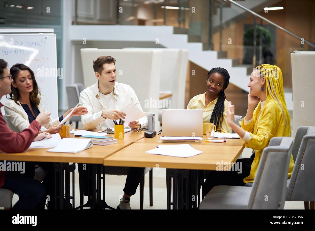 young start up team spending great time in the office, pleasant girl with yellow dreads telling jokes to her frineds, close up photo. good relationshi Stock Photo