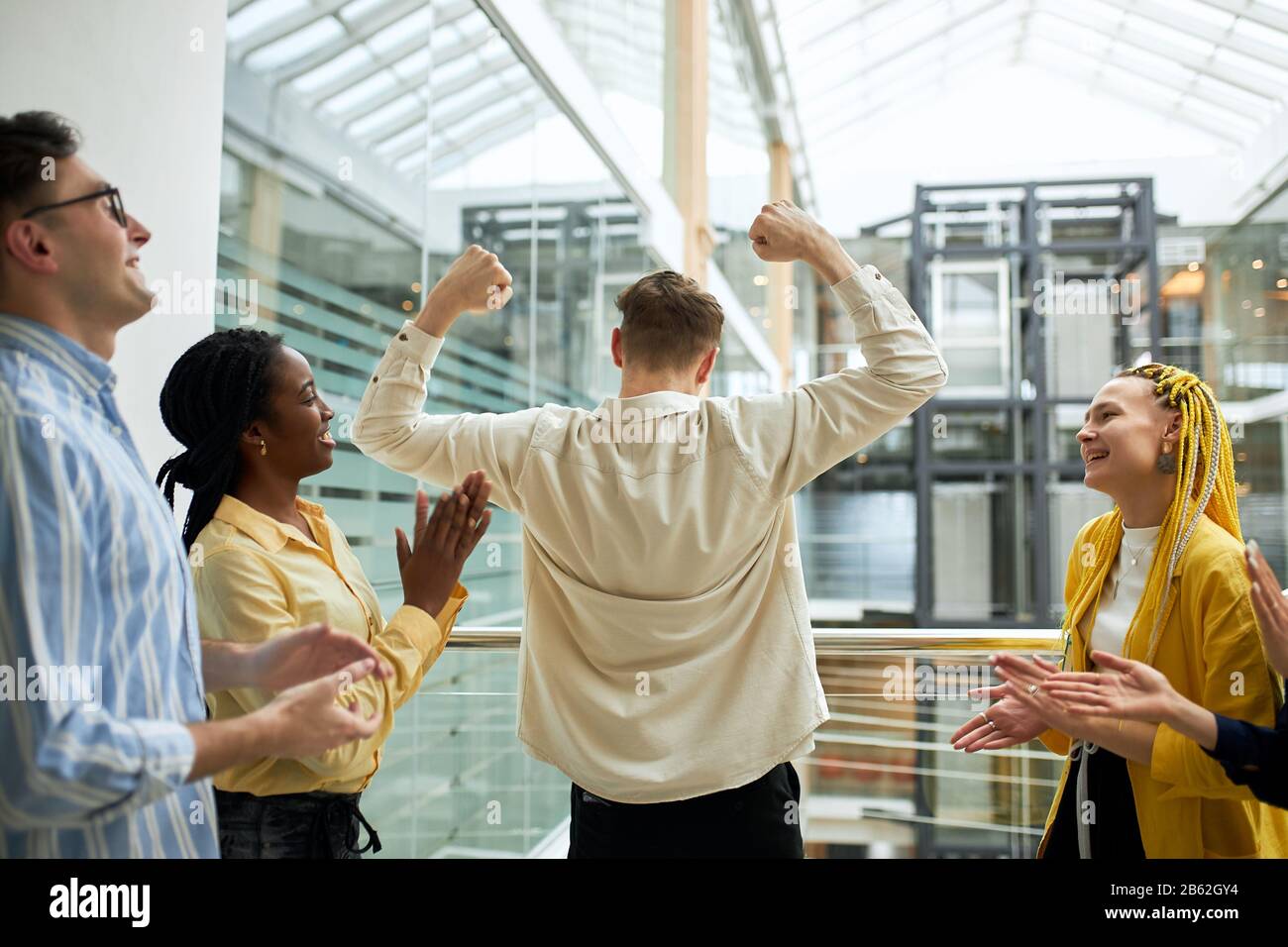 young ambitious people celebrating triumph with arms up, happiness, celebration. joy, fun . team alapping hands Stock Photo