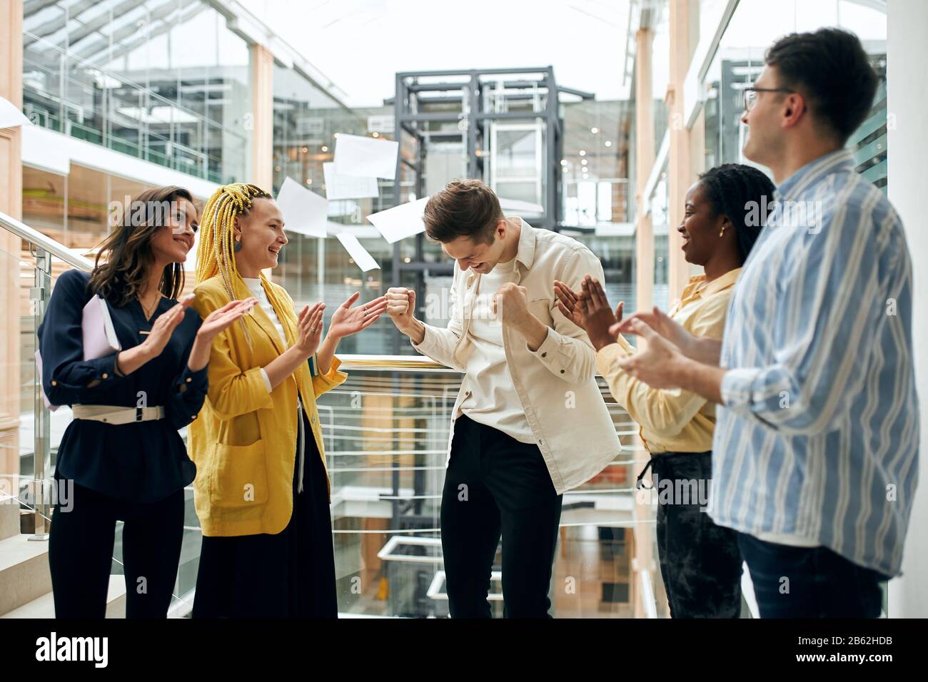 young men and women rejoicing at progress in deal, hurra. look of childish delight ,team shouting for joy Stock Photo