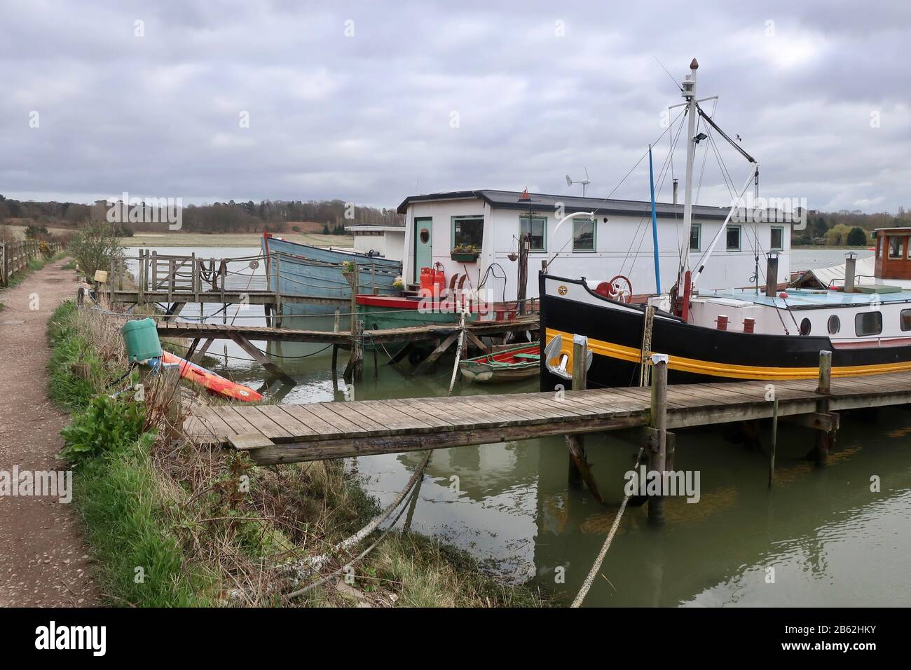 Woodbridge, Suffolk, UK - 9 March 2020: Houseboats seen on a wet and windy afternoon walk alongside the River Deben from Woodbridge to Melton. Stock Photo