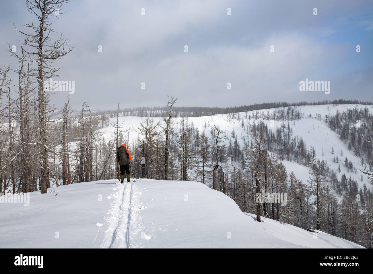 skiing trails man with backpack on snowy mountains Ridge Stock Photo