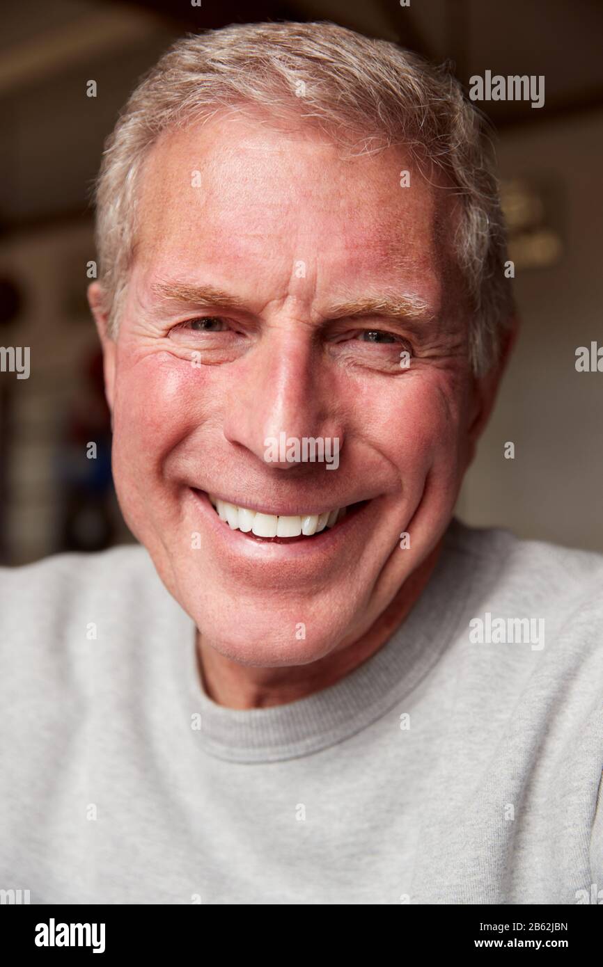 Portrait Of Smiling Senior Male Boxing Coach In Gym Standing By Old