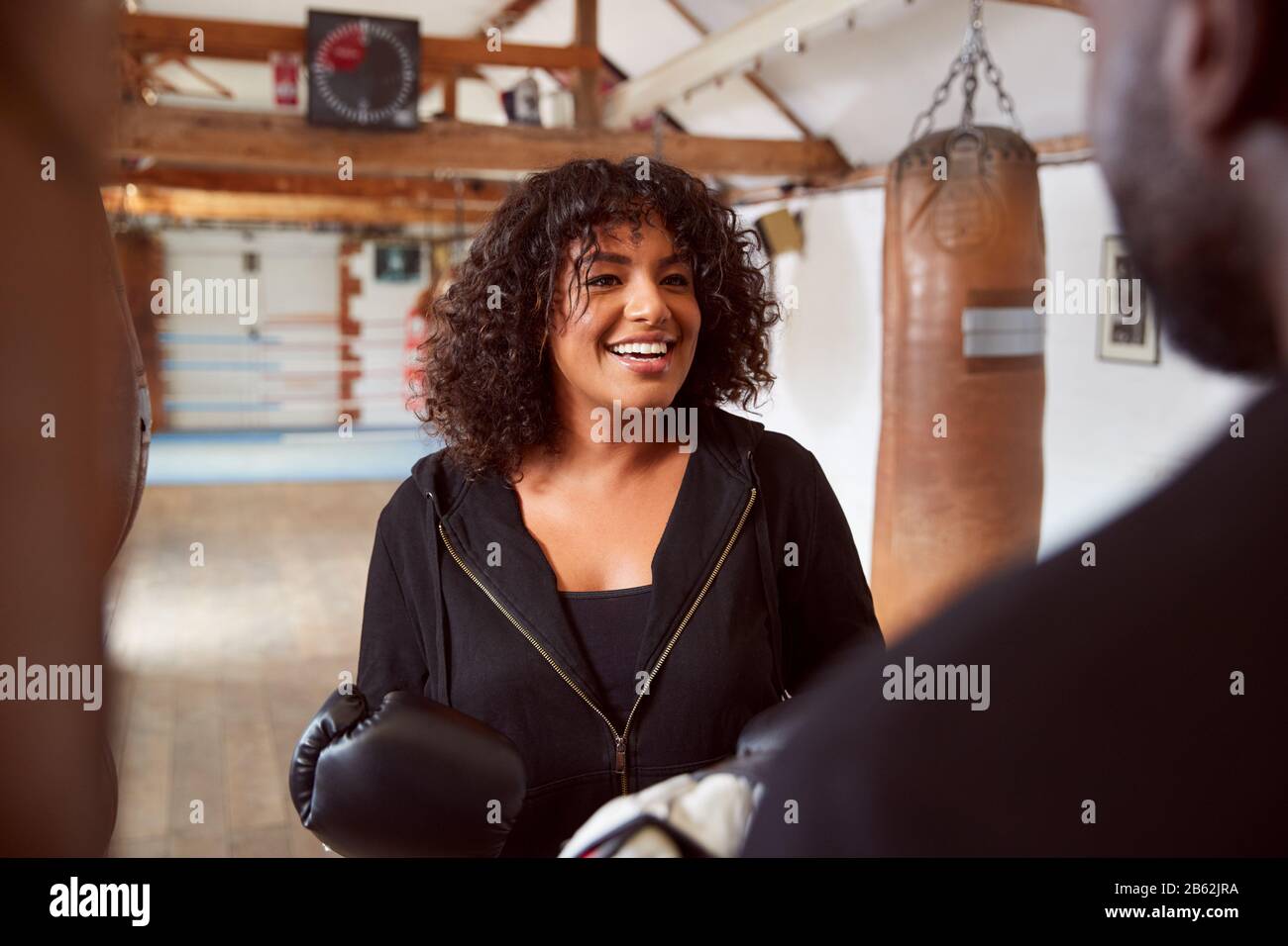 Male Personal Trainer Sparring With Female Boxer In Gym Using Training ...