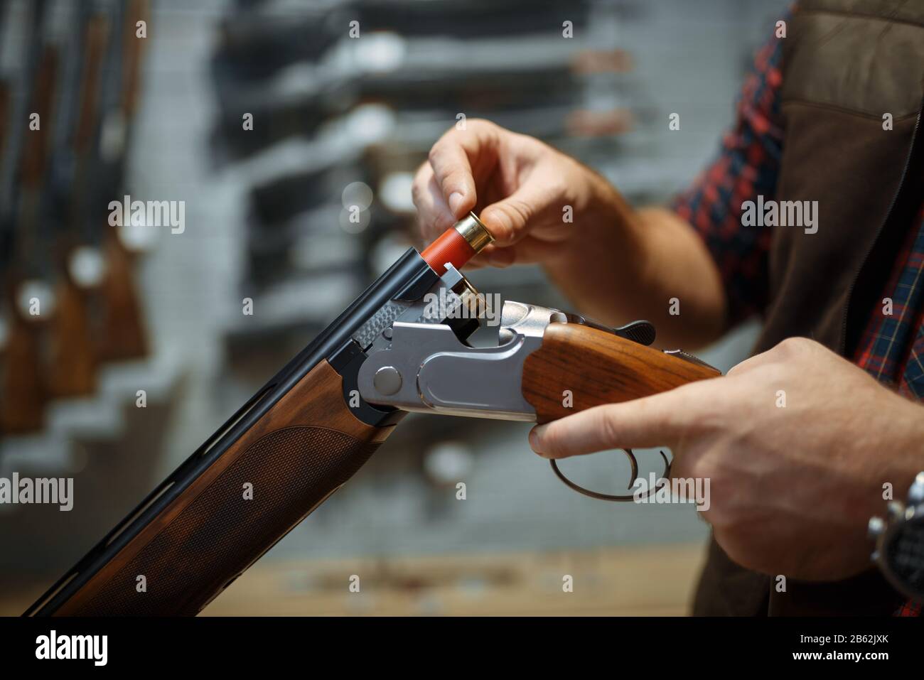 Man Loading Rifle Man loads a rifle, gun shop interior on background Stock Photo - Alamy