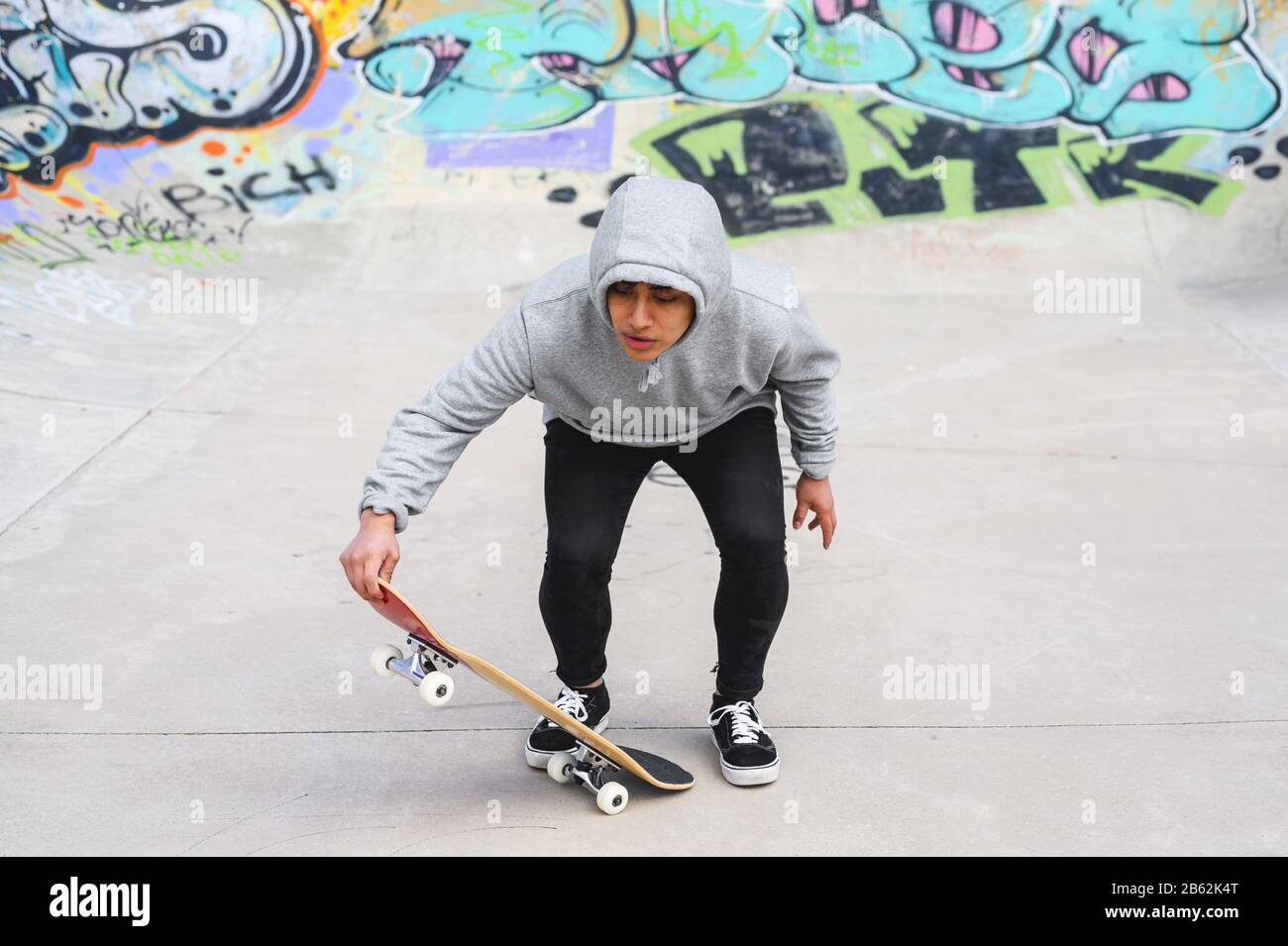 young skater doing jump trick at skate park . Stock Photo
