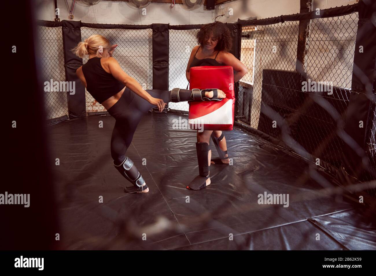 Two Female Mixed Martial Arts Fighters Kick Boxing Training In Gym