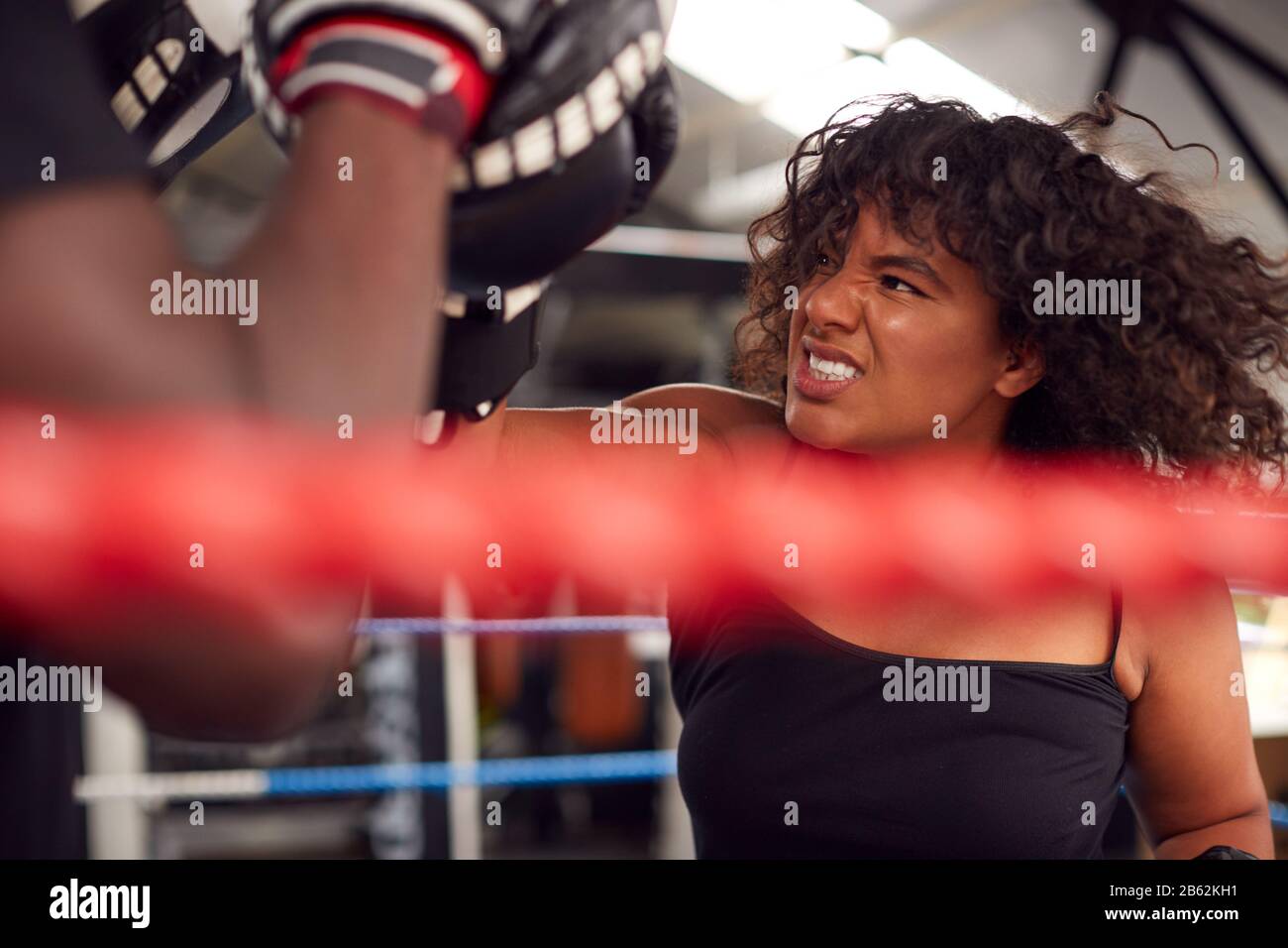 Male Personal Trainer Sparring With Female Boxer In Gym Using Training ...