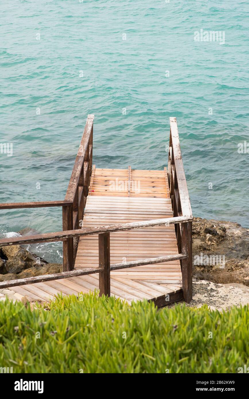 Wooden Pier on the Seashore with Blue Sea. Stock Photo
