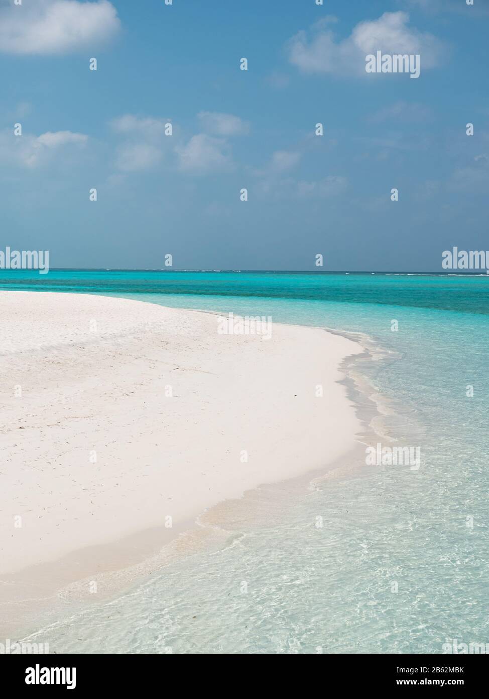 Idyllic Beach on Maldives on Meeru Island with Cloudy Sky and Indian Ocean. Stock Photo