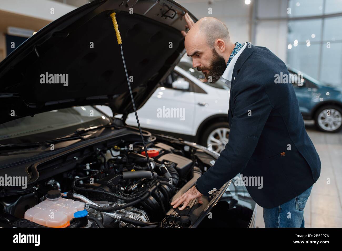 Man looking on transport engine in car dealership Stock Photo - Alamy