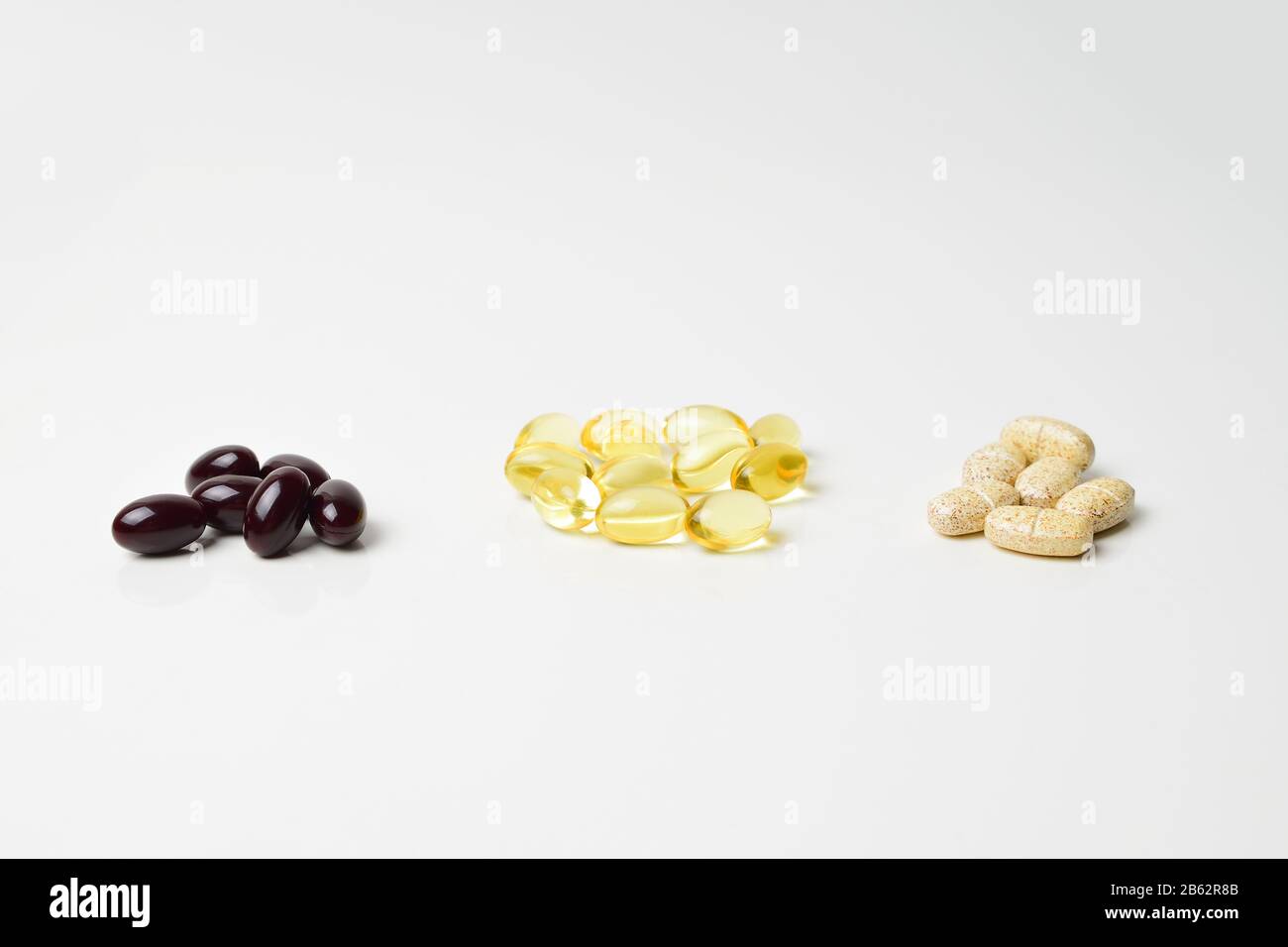 Fish oil, multivitamins and astaxanthin capsules in three bunches