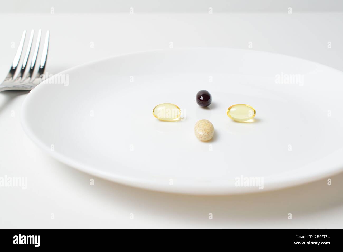 Multivitamin and mineral supplements. Plate with tablets. Meal replacement. Stock Photo