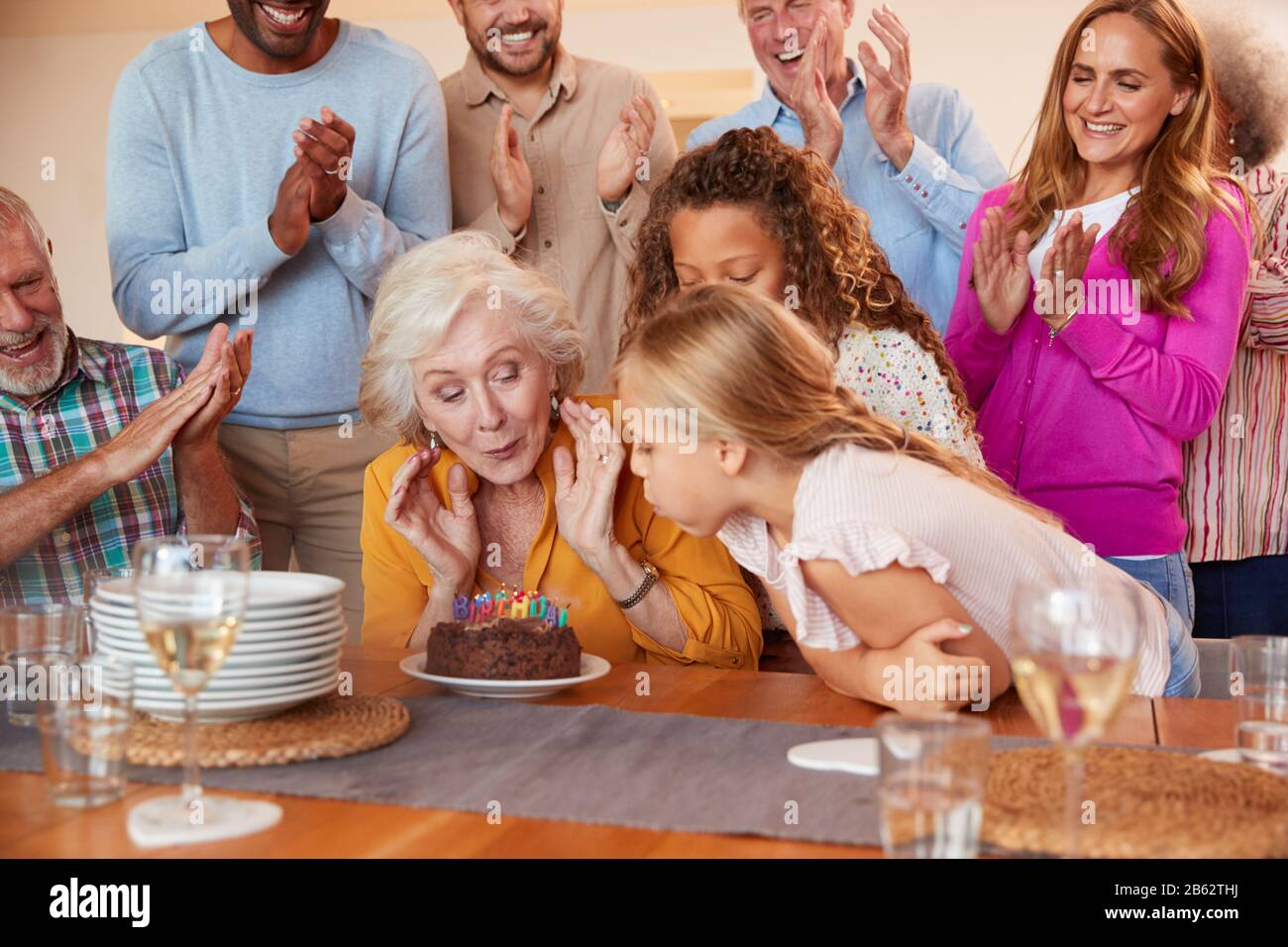 Multi-Generation Family Meet To Celebrate Grandmothers Birthday At Home Together Stock Photo