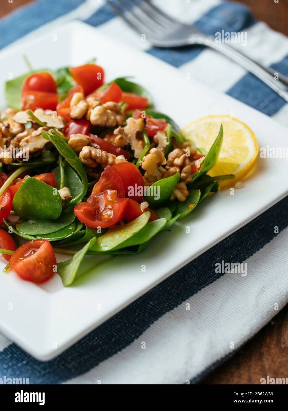Winter purslane salad with tomatoes and toasted walnuts. Stock Photo