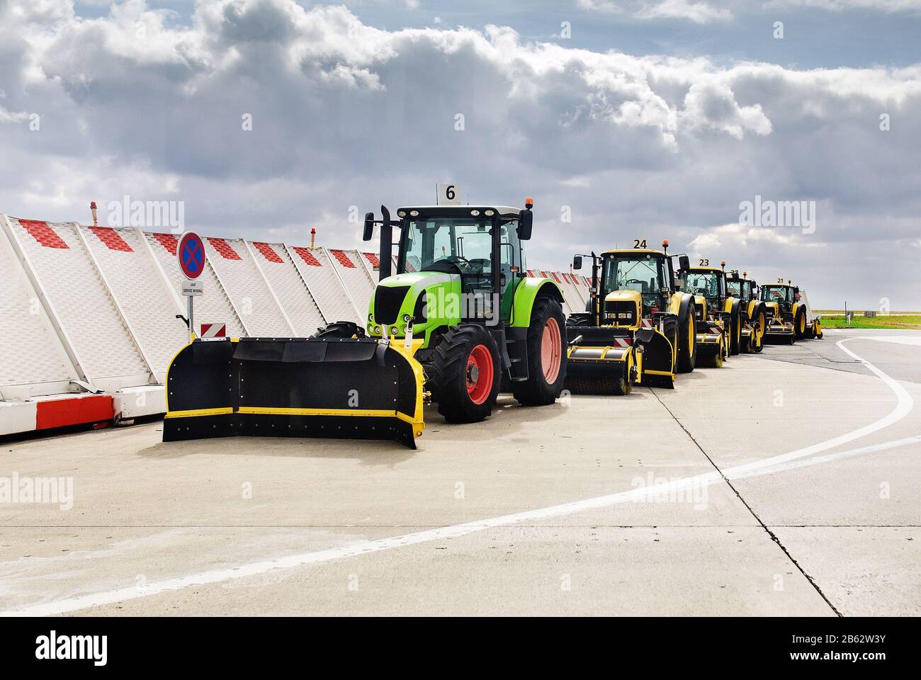A column of empty harvesting equipment and tractors with buckets Stock