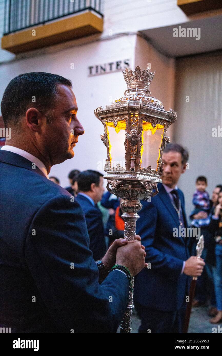 Man holding an ornate lantern during the Holy Week (Semana Santa) procession in Seville, Spain Stock Photo