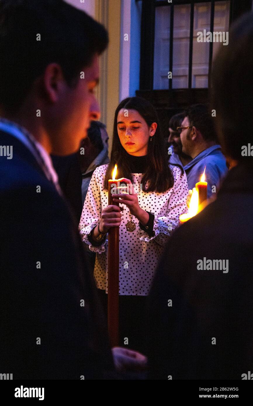Girl holding a candle during the Holy Week (Semana Santa) procession in Seville, Spain Stock Photo